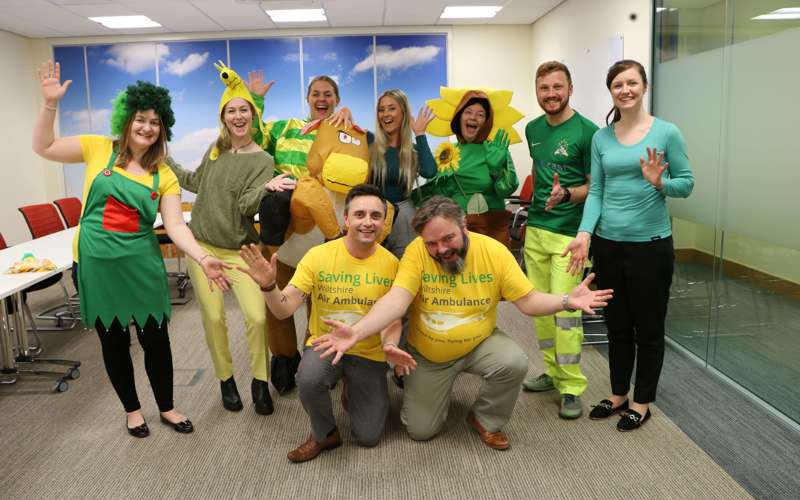 A group of colleagues wearing green and yellow attire to raise funds for Wiltshire Air Ambulance during Air Ambulance week. 