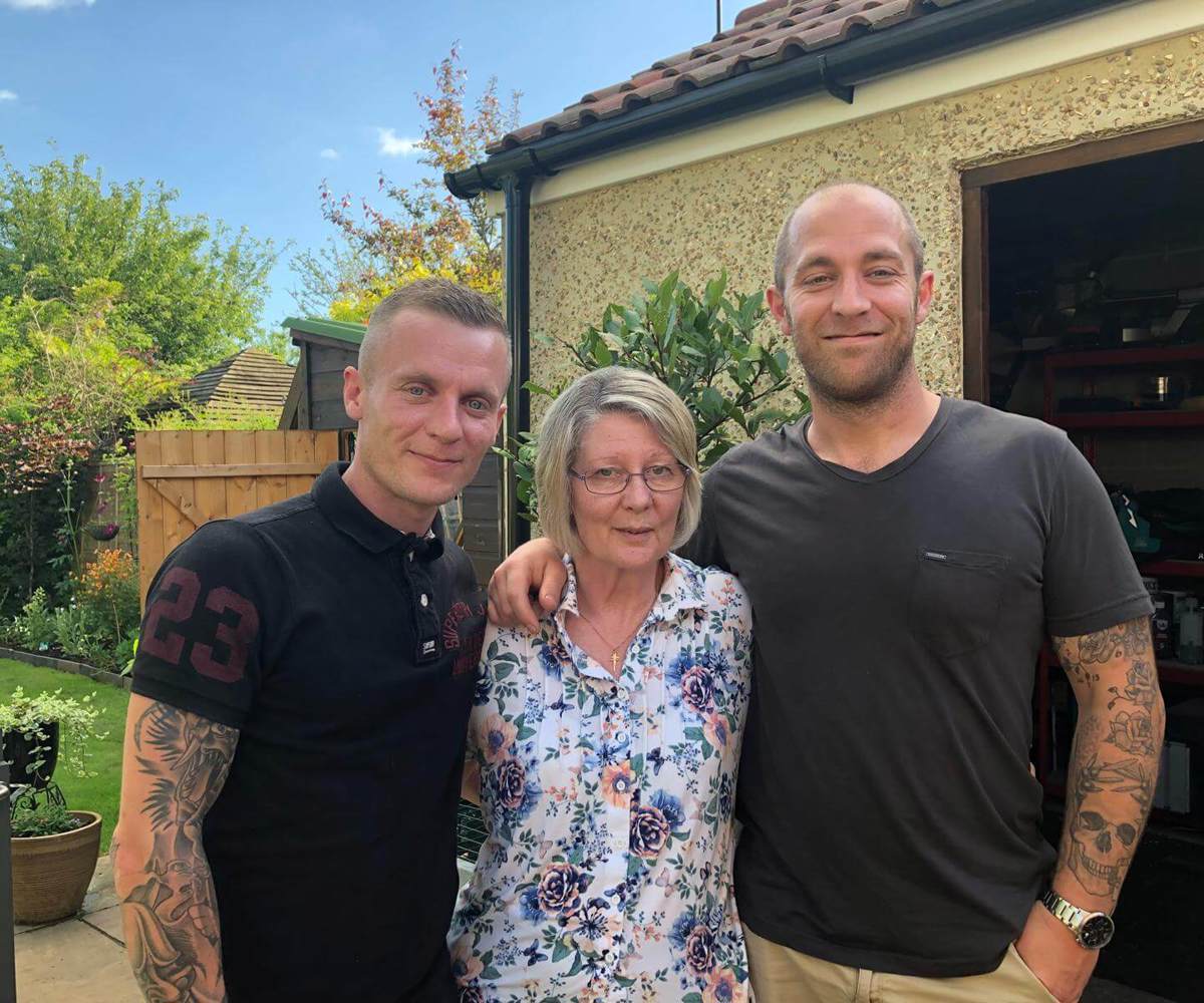 A former patient with their two children stood in a garden