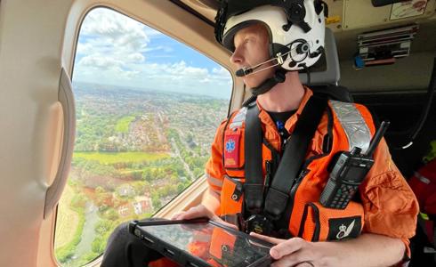 A critical care paramedic in flight looking over Wiltshire countryside