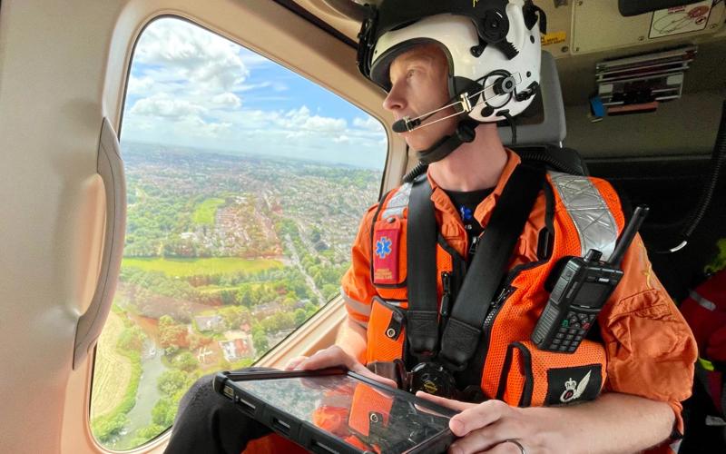 A critical care paramedic in flight looking over Wiltshire countryside