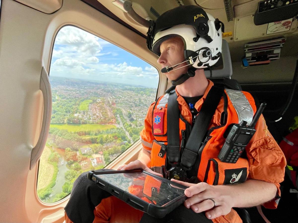 A critical care paramedic in flight looking over Wiltshire countryside