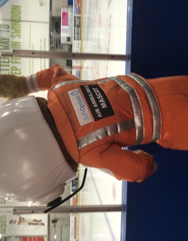 An air ambulance paramedic mascot cheering at the side of an ice rink