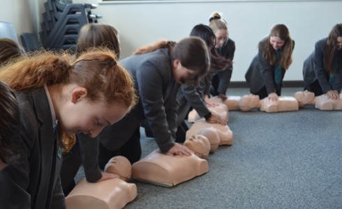 School children practicing CPR on a manekin